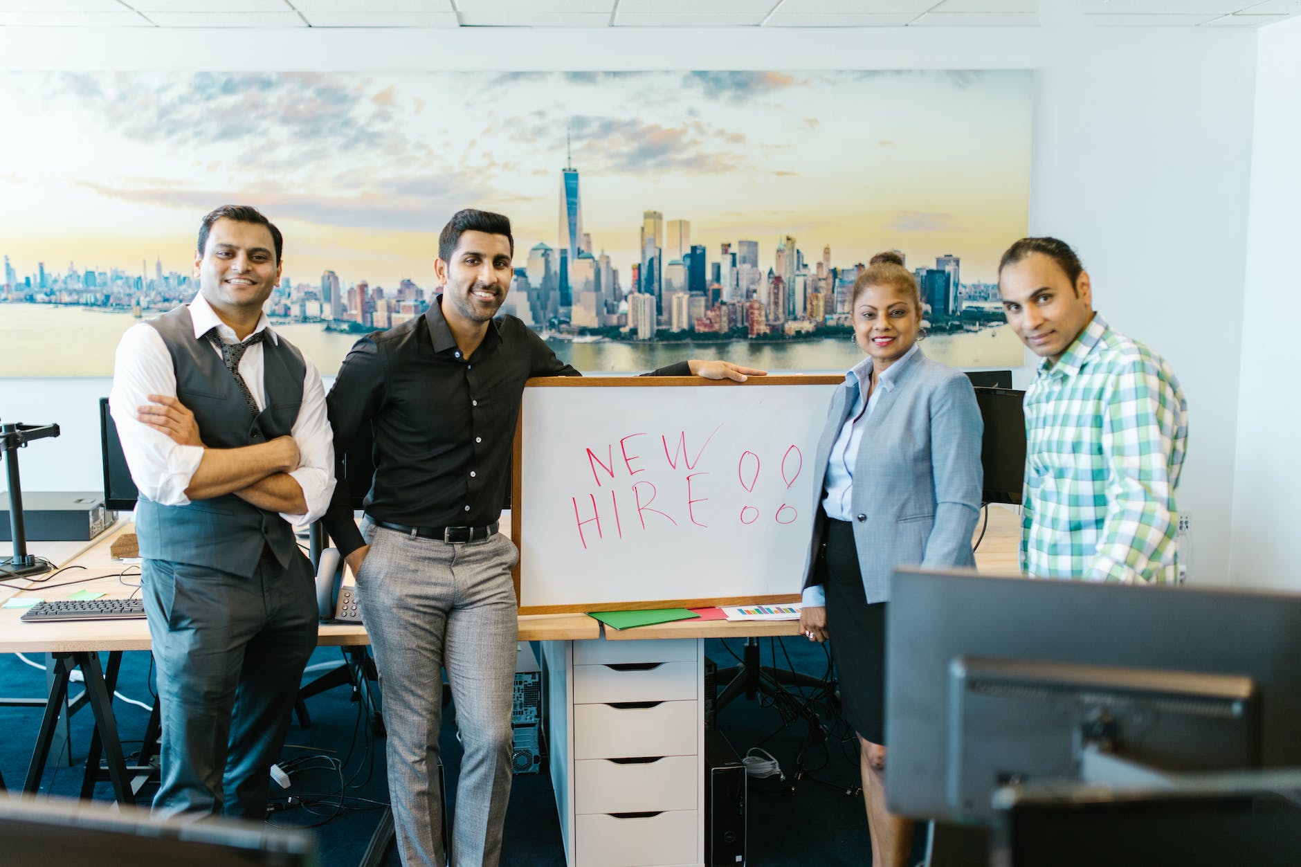 people standing beside a whiteboard that states, "new hire onboarding".